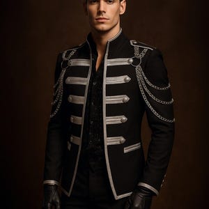May include: A black military-style jacket with silver detailing, including trim, buttons, and chain embellishments. The jacket has a high collar and is paired with black gloves and trousers. The look is formal and fashionable.