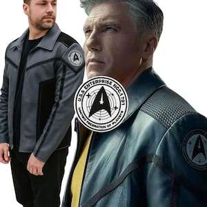 Può includere: Giacca grigia e nera con colletto e spalle nere. La giacca presenta una toppa con un'emblema a stella e la scritta "U.S.S. Enterprise NCC-1701". La giacca è una replica dell'uniforme di Star Trek.