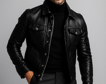 May include: A black leather jacket with a collared neckline and two chest pockets. The jacket is worn over a black roll neck sweater. The person is also wearing dark grey trousers.