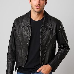 May include: Black leather jacket with decorative stitching and a notched collar. The jacket has a button-up front and is worn with a black t-shirt and blue jeans. A stylish outerwear piece.