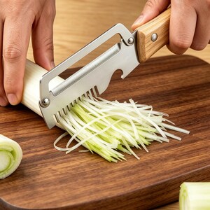 May include: A stainless steel kitchen tool with a light wood handle, featuring a sharp blade for slicing and a row of metal teeth for shredding spring onions into thin strips. The tool includes a small integrated notch for opening bottles.