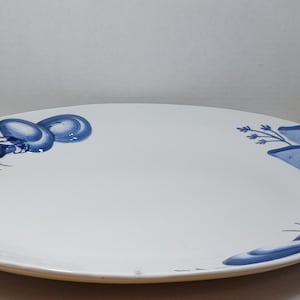 May include: An oval-shaped white ceramic serving platter featuring blue painted illustrations of lobsters and seashells on the left and right sides. The platter has a smooth, glossy finish and a wide, flat surface area for food presentation.