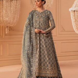 May include: A grey embroidered formal dress with long sleeves and a matching shawl. The dress features gold embellishments and a floral pattern. The shawl has a geometric design. Suitable for special occasions.