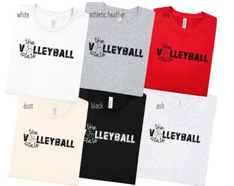 May include: A collection of six t-shirts in various colors: white, athletic heather, red, dust, black, and ash. Each shirt features the text "the VOLLEYBALL State" in a distressed font, with a volleyball graphic.
