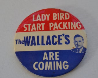 May include: A red, white, and blue button with the text "Lady Bird Start Packing The Wallace's Are Coming" and a picture of a man in a suit.