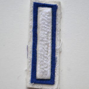 Chaqueta universitaria vintage recuperada con letras mayúsculas en azul y blanco, parche con letras L, I o 1