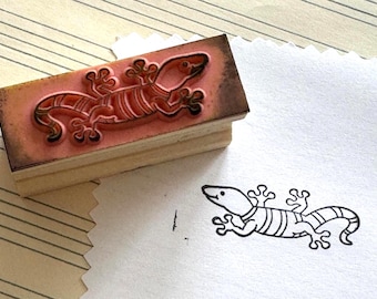 Carimbo de borracha montado em madeira com desenho de lagarto