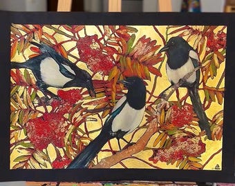 Puede incluir: Pintura original que presenta tres urracas posadas entre follaje rojo y dorado. Las aves tienen plumaje blanco y negro, con largas colas negras. El fondo es dorado texturizado y la obra está enmarcada en negro.