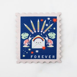 May include: A blue and white postage stamp with a rainbow, two snails, and pencils around a white envelope with a smiling face. The stamp says "FOREVER" at the bottom.