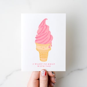 Puede incluir: Tarjeta de felicitación blanca con una ilustración de un cono de helado rosa. El cono es amarillo con una cara sonriente, y el texto dice "I WANT TO MELT WITH YOU". El helado es rosa y tiene un efecto de goteo.