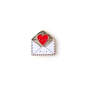 May include: Gold-tone enamel pin featuring a red heart with a smiling face inside a white envelope with a blue and red border.