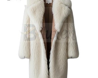 May include: A long, ivory-colored faux fur coat with a wide collar and a brown interior lining. The coat has long sleeves and a classic, open front design, offering a luxurious and warm aesthetic.
