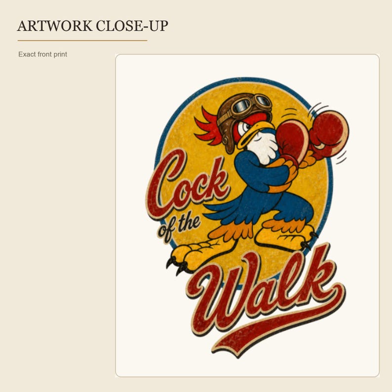 May include: A graphic print featuring a cartoon rooster wearing a brown aviator helmet and goggles, posed in a boxing stance with red gloves. The design is set against a yellow circular background with the text Cock of the Walk in red script.