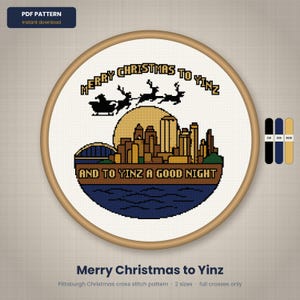 May include: A cross stitch pattern in a wooden hoop featuring a Pittsburgh skyline silhouette, a yellow moon, and Santa with reindeer. The text reads MERRY CHRISTMAS TO YINZ AND TO YINZ A GOOD NIGHT. Includes three color swatches on the right side.