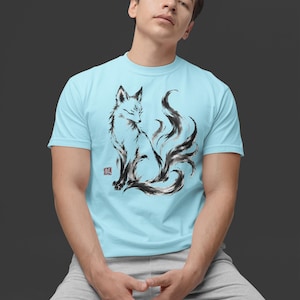 K&ouml;nnte beinhalten: Ein hellblaues T-Shirt mit kurzen &Auml;rmeln und einer schwarz-wei&szlig;en Tuschezeichnung eines mehrschw&auml;nzigen Fuchses im Profil. Die Grafik enth&auml;lt einen kleinen roten quadratischen Stempel mit einem japanischen Schriftzeichen links.
