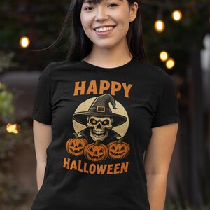 May include: Black t-shirt with an orange and white Halloween graphic. The graphic features a skull wearing a witch hat, with three jack-o'-lanterns below and the words "HAPPY HALLOWEEN" in orange.
