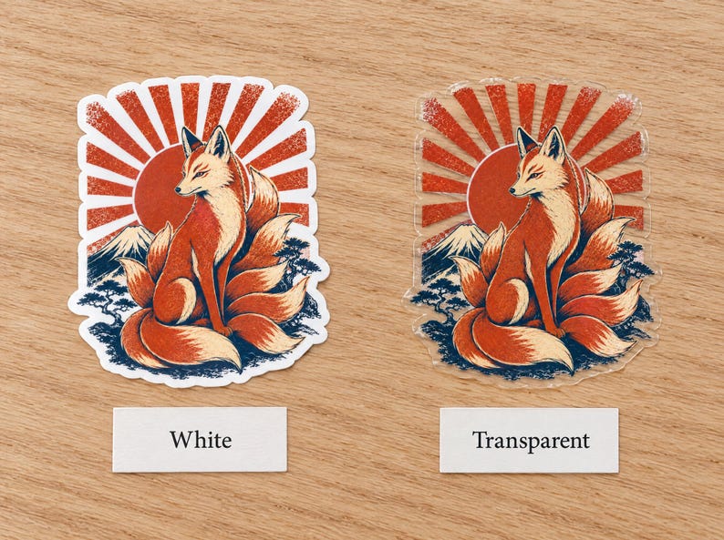 May include: Two stickers featuring a nine-tailed fox sitting before a red sunburst, a mountain, and trees. One sticker has a white border and backing, while the other is transparent. Labels below the stickers read White and Transparent.