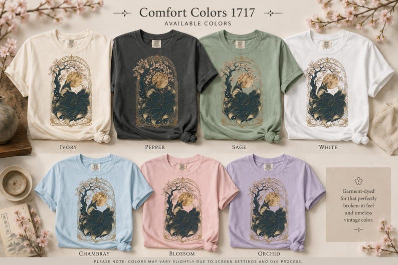 May include: Seven short-sleeved crew neck t-shirts in ivory, pepper, sage, white, chambray, blossom, and orchid. Each shirt features a graphic print of a fox with multiple tails under a full moon within an ornate, arched, gold-toned frame.