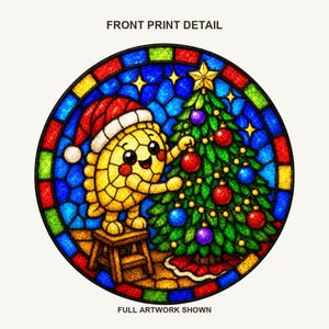 May include: A circular stained glass style graphic featuring a yellow character wearing a red Santa hat, standing on a wooden stool to decorate a green Christmas tree with red and blue ornaments. The text reads FRONT PRINT DETAIL and FULL ARTWORK SHOWN.