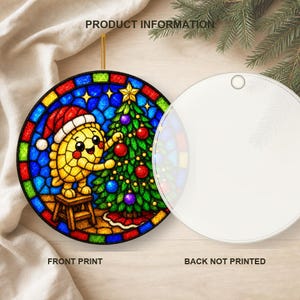 May include: A round, flat, white ornament featuring a stained-glass style illustration of a yellow turtle wearing a red Santa hat and decorating a green Christmas tree. The design includes blue, red, green, and yellow colours. The back is plain white.