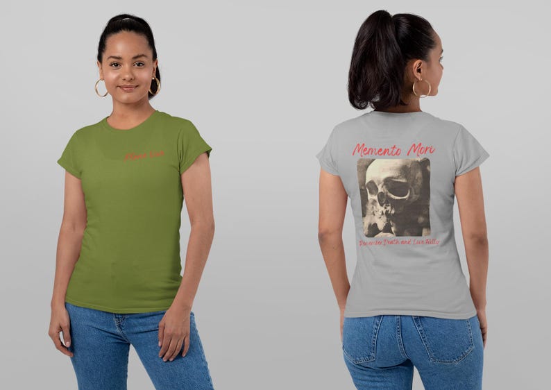 May include: Two t-shirts, one olive green and the other gray. The green shirt has the word 'Memento Mori' in red script on the front. The gray shirt features a skull image on the back with the words 'Memento Mori' above and 'Remember the death and live fully' below in red script.