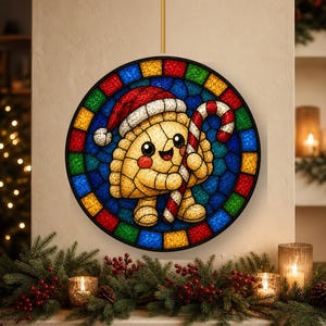 May include: A circular stained glass wall hanging featuring a smiling dumpling character wearing a red and white Santa hat and holding a red and white striped candy cane. The border consists of alternating red, blue, green, and yellow glass tiles.
