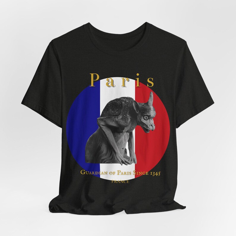 May include: Black t-shirt with a grey gargoyle statue inside a blue, white, and red circle, similar to the French flag. The word "Paris" is above the circle, and "Guardian of Paris Since 1345" is below.