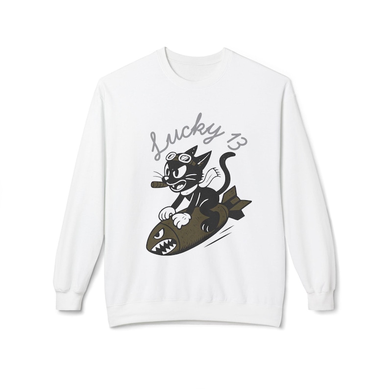 May include: White sweatshirt featuring a cartoon cat riding a bomb. The black cat wears goggles and a scarf, holding a cigar. The words "Lucky 13" are written above the cat in a cursive font. The bomb has a shark-like mouth.