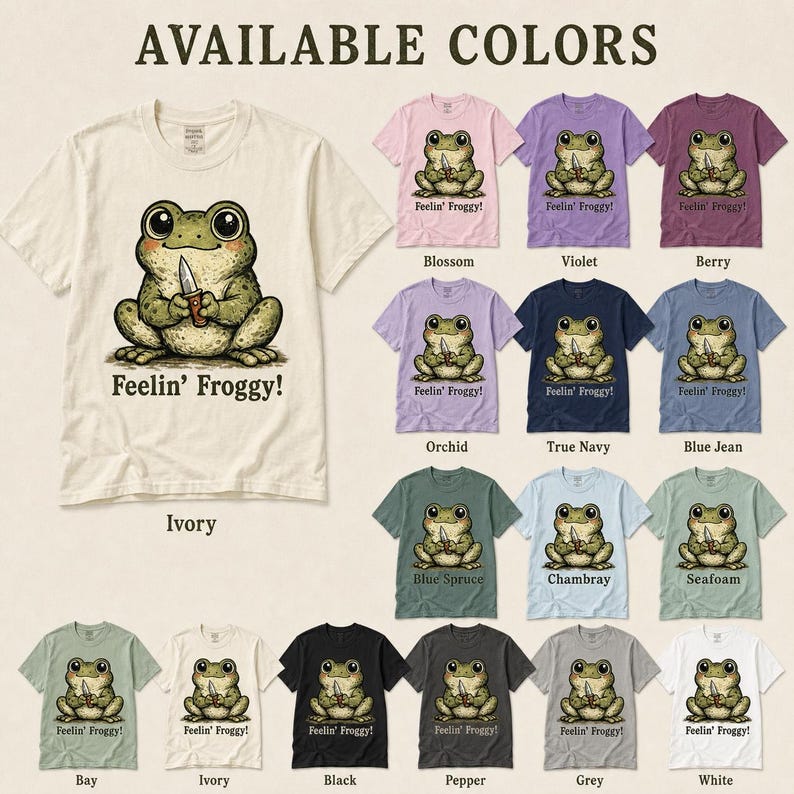 Może przedstawiać: Kolekcja koszulek z kr&oacute;tkim rękawem w r&oacute;żnych kolorach, każda z grafiką żaby trzymającej n&oacute;ż i napisem 'Feelin' Froggy!' poniżej. Dostępne kolory to kość słoniowa, blossom, fioletowy, berry, orchid, true navy, blue jean, blue spruce, chambray, seafoam, bay, czarny, pepper, szary i biały.