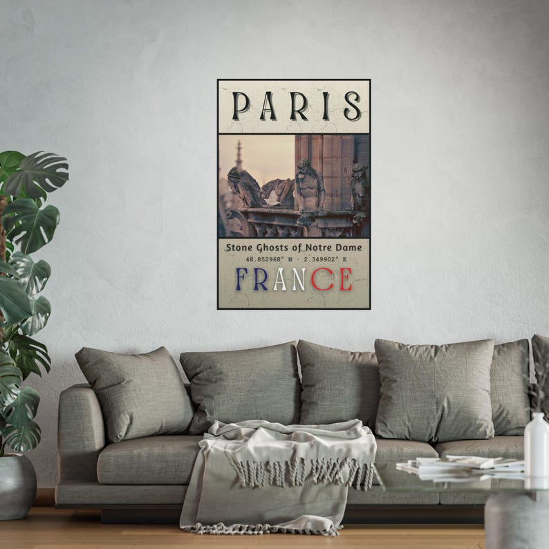 May include: A framed print featuring the word "PARIS" at the top, with an image of Notre Dame's gargoyles below. The word "FRANCE" is at the bottom. The print has a vintage aesthetic and is displayed on a wall above a gray sofa.
