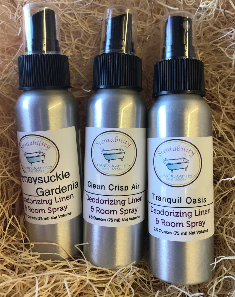 Pode incluir: Tr&ecirc;s frascos de spray prateados com tampas pretas e r&oacute;tulos brancos. Os r&oacute;tulos dizem "Honeysuckle Gardenia", "Clean Crisp Air" e "Tranquil Oasis". Cada frasco cont&eacute;m 75 ml de spray desodorizante para roupa de cama e ambiente.
