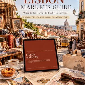 May include: A digital tablet displaying a Lisbon Markets guide, a white ceramic cup labelled Bica, a custard tart, a canvas tote bag with Lisbon text, a map, and sunglasses on a stone table, with a blurred outdoor market scene in the background.