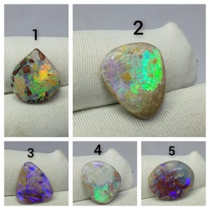 Pode incluir: Cinco opalas polidas de formato irregular numeradas de 1 a 5. Cada pedra exibe um jogo de cores único, incluindo flashes de verde, azul, roxo e laranja contra uma matriz de inclusões minerais em tons de bege, marrom e creme.