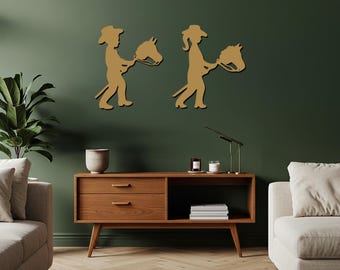May include: Two golden-colored wall art pieces depicting children with stick horses. The figures are in profile, one wearing a cowboy hat and the other with a ponytail. The art is mounted on a dark green wall above a wooden cabinet.
