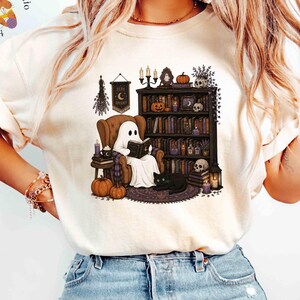 Maglietta Comfort Colors® per amanti dei libri a tema Halloween, maglietta con fantasmi e letture, regalo perfetto per chi ama leggere in un'atmosfera accogliente.