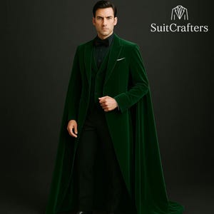 May include: A man in a dark green velvet suit with a matching cape. The suit includes a vest, dress shirt, and bow tie. The logo "SuitCrafters" is in the upper right corner. The background is dark.