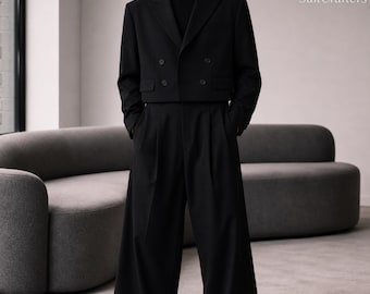 May include: A black double-breasted cropped blazer with a notched lapel and four buttons, paired with matching high-waisted wide-leg trousers and a black turtleneck sweater. The text SuitCrafters is visible in the upper right corner.