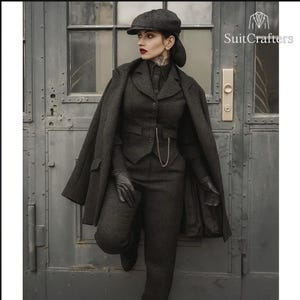 May include: A dark gray herringbone tweed suit consisting of a tailored vest, trousers, and a matching coat draped over the shoulders. Includes a newsboy cap, black leather gloves, and a silver pocket watch chain. Text reads SuitCrafters.