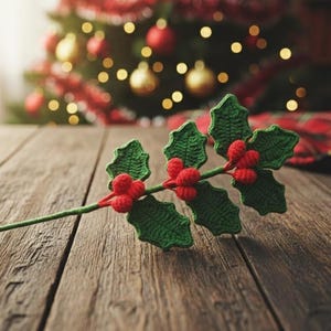 May include: A crocheted holly sprig with green leaves and red berries lies on a wooden surface. The sprig is a festive decoration, ideal for Christmas. A green circle with the text "PDF PATTERN" is in the background.