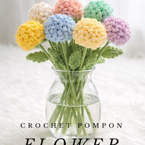 Può includere: Un vaso di vetro trasparente contiene un bouquet di fiori a pompon all'uncinetto colorati. I fiori sono gialli, blu, rosa, verdi e viola. I gambi sono verdi e il testo "CROCHET POMPON FLOWER PATTERN" è sotto.