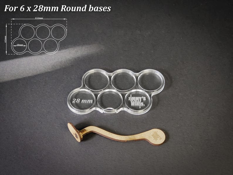 May include: A clear acrylic base for six 28mm round bases, with the text "Jimmy's Minis" etched on it. A wooden tool is also included. The text "For 6 x 28mm Round bases" is at the top.