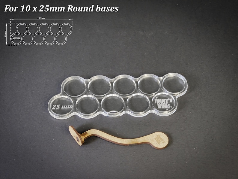 May include: Clear acrylic base for 10 miniature figures with 25 mm round bases. Includes a wooden handle. The text "For 10 x 25mm Round bases" is at the top. The base has 10 circular cutouts.