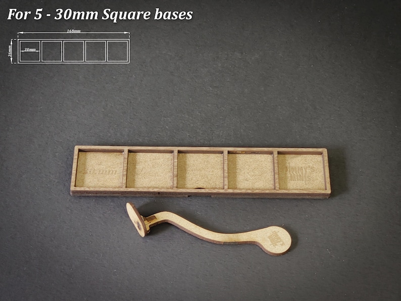Puede incluir: Base de madera para 5 miniaturas cuadradas, con un asa curva. La base tiene cinco ranuras rectangulares, cada una de 30 mm cuadrados. El texto "For 5 - 30mm Square bases" est&aacute; en la parte superior. El asa facilita el transporte.