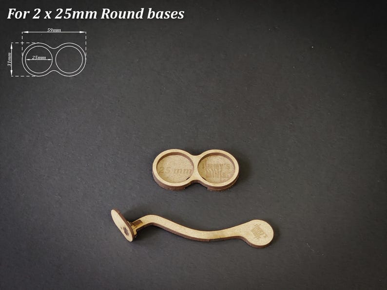 May include: Two wooden round bases, each 25mm in diameter, and a curved wooden handle. The bases are connected and have text that reads "25 mm". The handle has a small, circular design on one end. The text "For 2 x 25mm Round bases" is at the top.