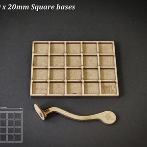 Puede incluir: Una bandeja de madera con 20 compartimentos cuadrados, cada uno de 20 mm, y un asa de madera curvada. El texto "For 20 x 20mm Square bases" est&aacute; en la parte superior. Un diagrama muestra las dimensiones.