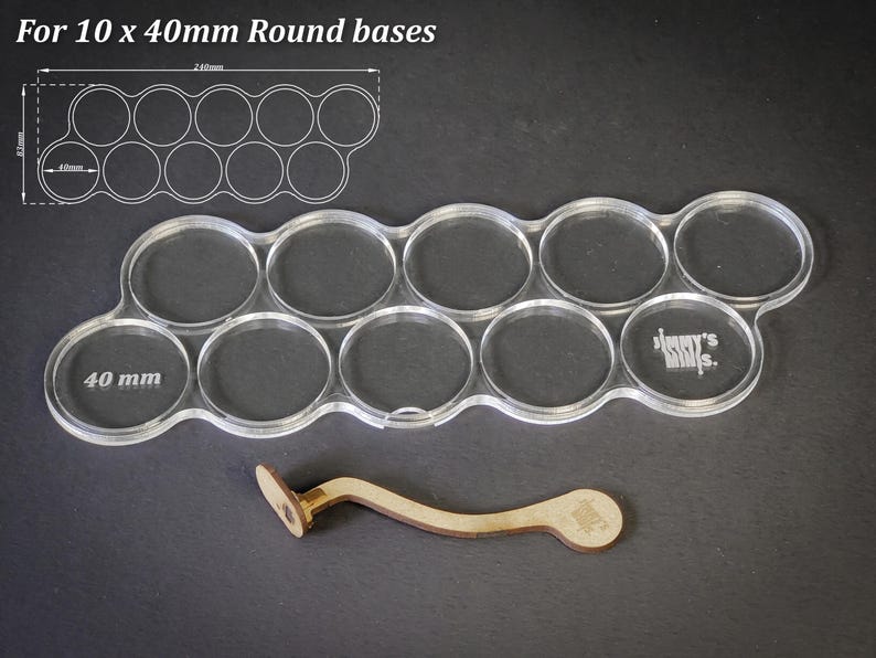 May include: Clear acrylic base holder for 10 x 40mm round bases, with a wooden handle. The holder has a wavy design with ten circular cutouts. The text "For 10 x 40mm Round bases" is at the top. The holder is 24cm long.