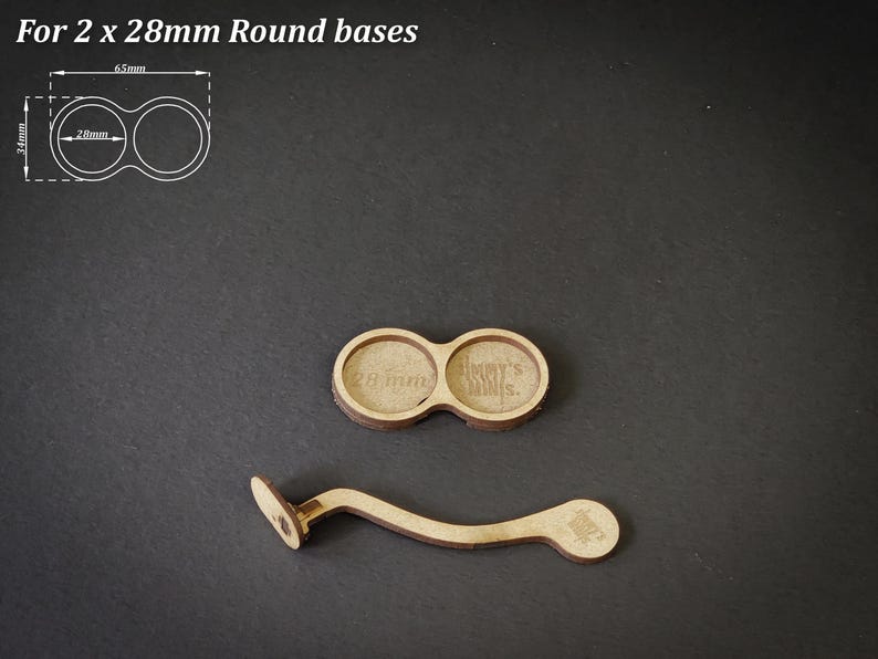 May include: Two wooden round bases for miniatures, each with a 28mm diameter, and a curved wooden handle. The text "For 2 x 28mm Round bases" is at the top. The handle has a small circular base.