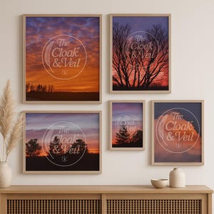 May include: A set of framed art prints depicting sunset scenes and tree silhouettes. Each print is in a wooden frame and features the text "The Cloak & Veil" in a circular design. The colours are orange, purple, and brown.