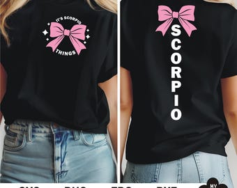 Può includere: Maglietta nera con un fiocco rosa e il testo "It's Scorpio Things" sul davanti e la parola "Scorpio" verticalmente sul retro.