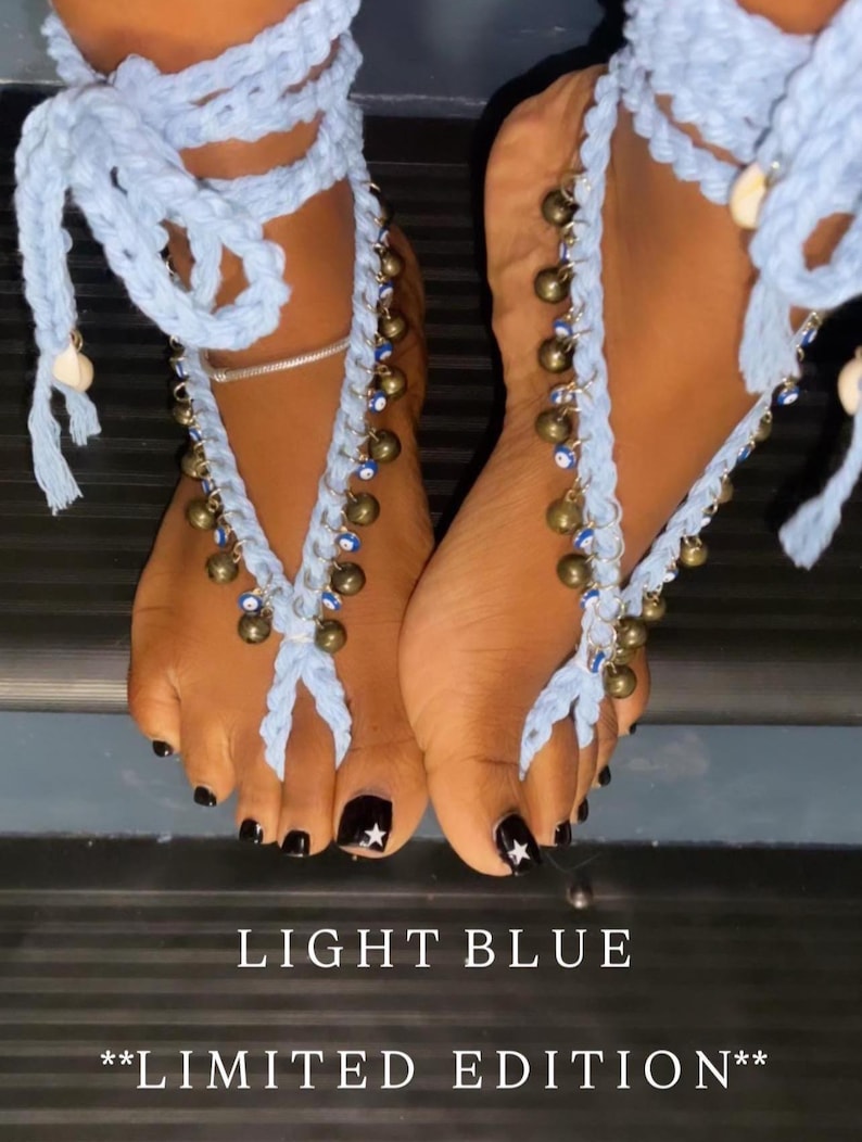 Puede incluir: Joyer&iacute;a de pie de ganchillo azul claro con cascabeles dorados colgantes y cuentas azules. La joyer&iacute;a se envuelve alrededor del pie y el tobillo. El texto "LIGHT BLUE" y "**LIMITED EDITION**" est&aacute; en la parte inferior de la imagen.